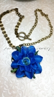 Large blue polymer clay flower with a Swarovski rivoli center, and brass ox book chain.