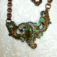This altered piece had been on my work table for over a year. Rhinestone chain accent and book chain finished it.